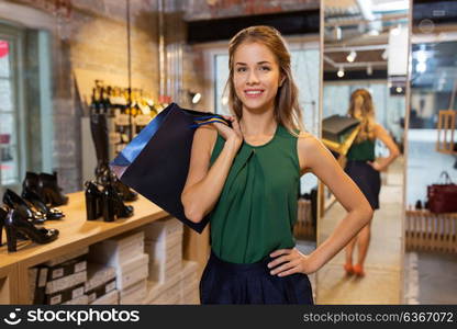 sale, fashion and people concept - happy young woman with shopping bags at at at shoestore. happy young woman with shopping bags at shoestore