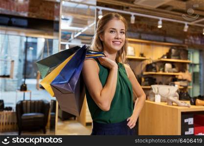 sale, fashion and people concept - happy young woman with shopping bags at at at shoestore. happy young woman with shopping bags at shoestore