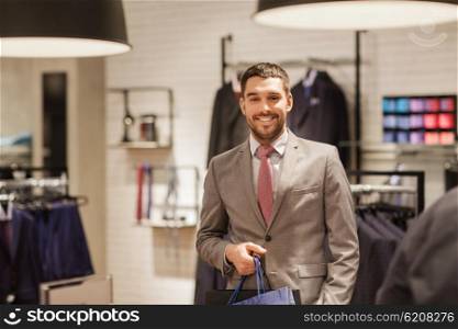 sale, fashion, retail, business style and people concept - happy man with shopping bags at clothing store