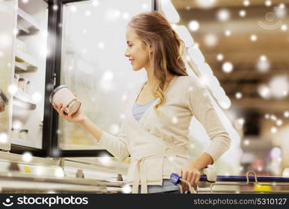 sale, food, shopping, consumerism and people concept - woman with ice cream at grocery store or supermarket freezer over snow. woman with ice cream at grocery store freezer