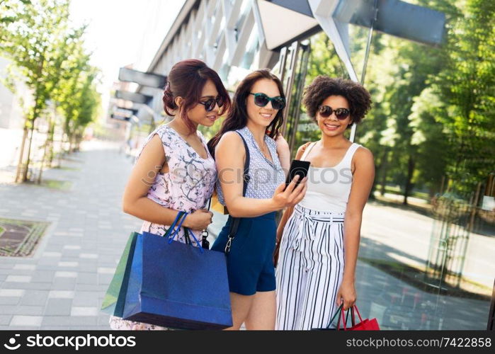 sale, friendship and technology concept - happy young women with shopping bags taking selfie by smartphone in summer city. women with shopping bags taking selfie in city