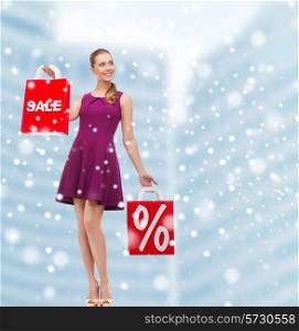 sale, gifts, christmas, holidays and people concept - smiling woman in purple dress holding shopping bags with percentage sign over mall background