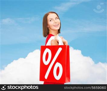 sale, gifts, christmas, holidays and people concept - smiling woman in red dress with shopping bags and percent sign over blue sky and white cloud background