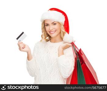 sale, gifts, christmas, xmas concept - smiling woman in santa helper hat with shopping bags and credit card