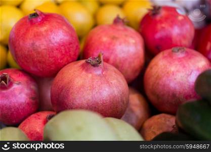 sale, harvest, food, fruits and agriculture concept - close up of pomegranate at street farmers market