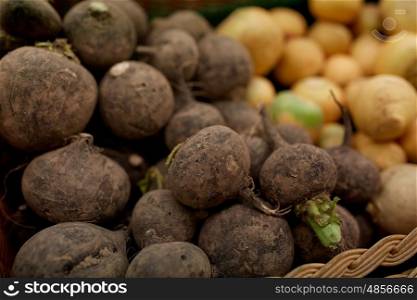 sale, harvest, food, vegetables and agriculture concept - close up of black radish at grocery store or market
