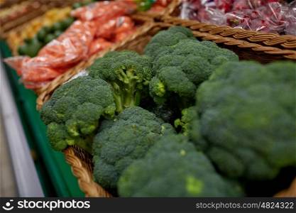 sale, harvest, food, vegetables and agriculture concept - close up of broccoli at grocery store or market
