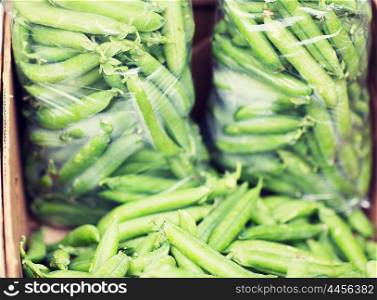 sale, harvest, food, vegetables and agriculture concept - close up of green peas in box at street market