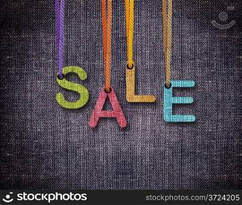 Sale letters hanging strings with blue sackcloth background.. Sale