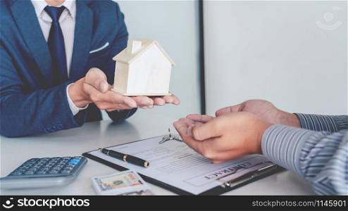Sale representative offer house purchase contract to buy a house or apartment or discussing about loans and interest rates