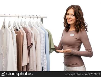 sale, shopping and business concept - happy female shop assistant or saleswoman with clothes on hanger over white background. happy female shop assistant with clothes on hanger
