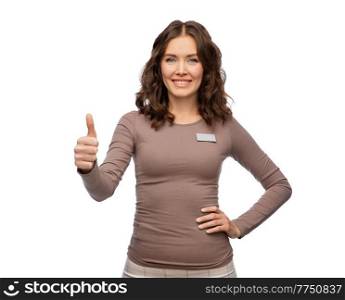 sale, shopping and business concept - happy female shop assistant with name tag showing thumbs up over white background. happy female shop assistant showing thumbs up