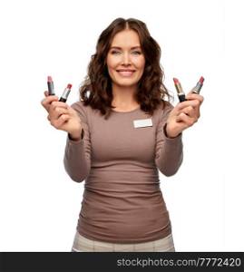 sale, shopping and make up concept - happy female saleswoman or makeup artist with lipsticks over white background. smiling saleswoman or makeup artist with lipsticks