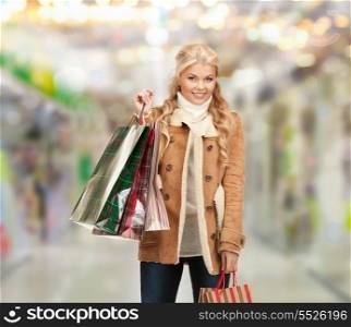 sale, shopping and mall concept - lovely woman with shopping bags at shopping mall