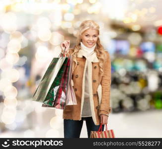 sale, shopping and mall concept - lovely woman with shopping bags at shopping mall