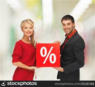 sale, shopping and mall concept - smiling man and woman with percent sign at shopping mall