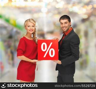 sale, shopping and mall concept - smiling man and woman with percent sign at shopping mall