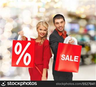 sale, shopping and mall concept - smiling man and woman with shopping bag at shopping mall
