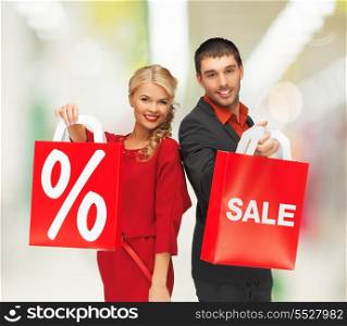 sale, shopping and mall concept - smiling man and woman with shopping bag at shopping mall