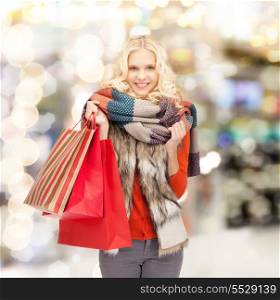 sale, shopping and mall concept - smiling teenage girl with shopping bags at shopping mall