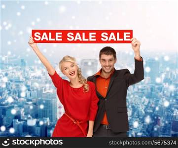 sale, shopping, christmas, holidays and people concept - smiling man and woman in red dress with red sale sign over snowy city background