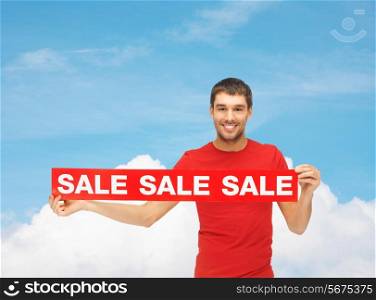 sale, shopping, christmas, holidays and people concept - smiling man in red t-shirt with sale sign