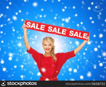 sale, shopping, christmas, holidays and people concept - smiling woman in red dress with red sale sign over blue snowy background