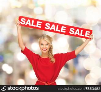 sale, shopping, christmas, holidays and people concept - smiling woman in red dress with red sale sign over lights background