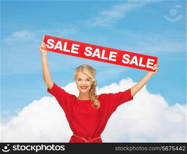 sale, shopping, christmas, holidays and people concept - smiling woman in red dress with red sale sign over blue sky and white cloud background