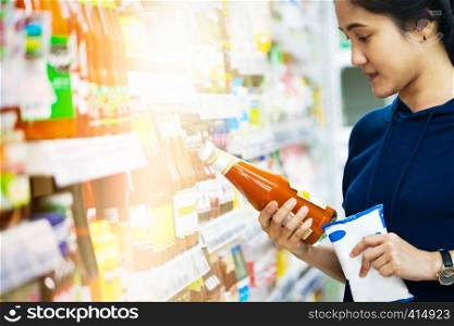 sale, shopping, consumer, woman choosing goods at grocery store or supermarket store
