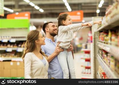 sale, shopping, consumerism and people concept - happy family with child buying food at grocery store or supermarket