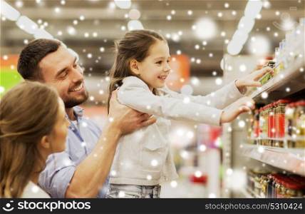 sale, shopping, consumerism and people concept - happy family with child buying food at grocery store or supermarket over snow. happy family buying food at grocery store