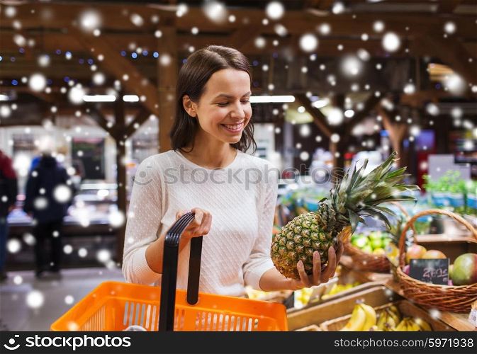 sale, shopping, consumerism and people concept - happy young woman with food basket in market or grocery store over snow effect