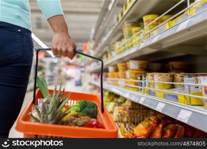 sale, shopping, consumerism and people concept - woman with food basket at grocery store or supermarket