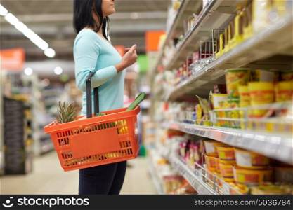 sale, shopping, consumerism and people concept - woman with food basket at grocery store or supermarket. woman with food basket at grocery or supermarket