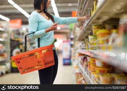 sale, shopping, consumerism and people concept - woman with food basket at grocery store or supermarket. woman with food basket at grocery or supermarket