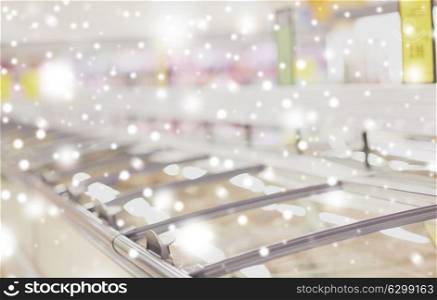 sale, shopping, consumerism and storage concept - freezers at grocery store over snow. freezers at grocery store