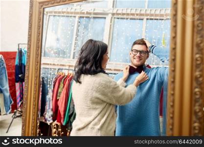 sale, shopping, fashion and people concept - couple choosing bowtie at vintage clothing store. couple choosing bowtie at vintage clothing store