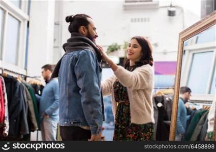 sale, shopping, fashion and people concept - couple choosing clothes at vintage clothing store. couple choosing clothes at vintage clothing store
