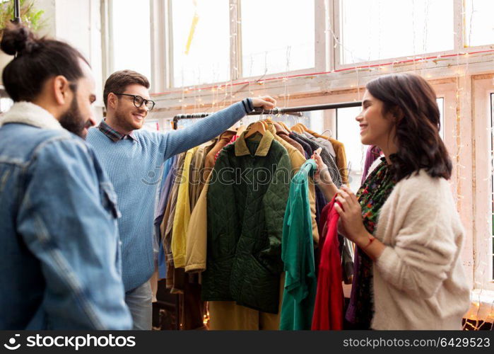 sale, shopping, fashion and people concept - friends choosing clothes at vintage clothing store. friends choosing clothes at vintage clothing store