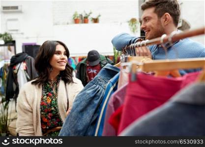 sale, shopping, fashion and people concept - happy couple at vintage clothing store hanger. happy couple at vintage clothing store hanger. happy couple at vintage clothing store hanger