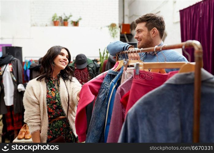 sale, shopping, fashion and people concept - happy couple at vintage clothing store hanger. happy couple at vintage clothing store hanger. happy couple at vintage clothing store hanger