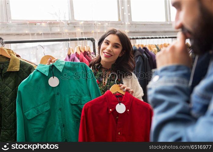 sale, shopping, fashion and people concept - happy couple choosing clothes at vintage clothing store. couple choosing clothes at vintage clothing store. couple choosing clothes at vintage clothing store