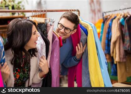 sale, shopping, fashion and people concept - happy couple having fun at vintage clothing store hanger. happy couple having fun at vintage clothing store. happy couple having fun at vintage clothing store