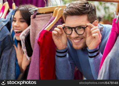 sale, shopping, fashion and people concept - happy couple having fun at vintage clothing store hanger. happy couple having fun at vintage clothing store. happy couple having fun at vintage clothing store