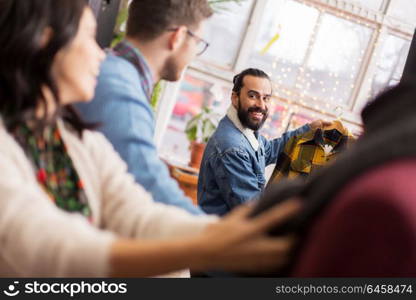 sale, shopping, fashion and people concept - happy friends choosing clothes at vintage clothing store. friends choosing clothes at vintage clothing store