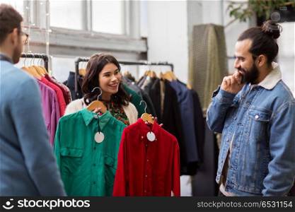 sale, shopping, fashion and people concept - happy friends choosing clothes at vintage clothing store. friends choosing clothes at vintage clothing store. friends choosing clothes at vintage clothing store