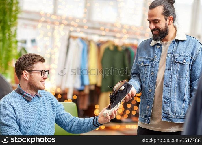 sale, shopping, fashion and people concept - male friends choosing shoes at vintage clothing store. friends choosing shoes at vintage clothing store. friends choosing shoes at vintage clothing store
