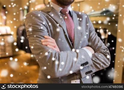 sale, shopping, fashion, style and people concept - close up of man in suit and tie at clothing store over snow