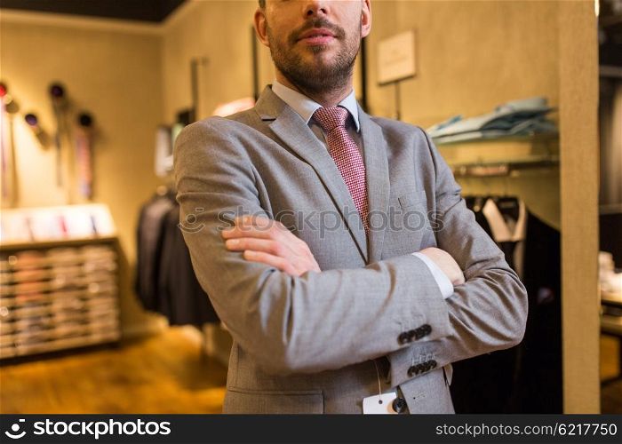 sale, shopping, fashion, style and people concept - close up of man in suit and tie at clothing store